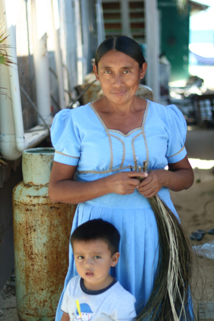 Mayan woman weaving baskets from palm leaves on Caye Caulker in Belize.