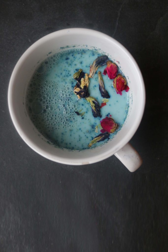 Full moon ritual milk with butterfly pea flowers and coconut sugar.