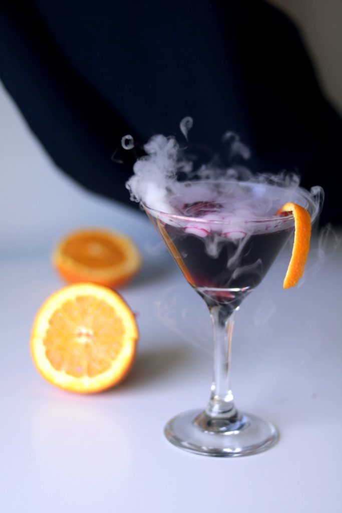 Spooky black magic Samhain cocktail. Step through the Veil Between Wordls with this dramatic dry ice martini recipe.