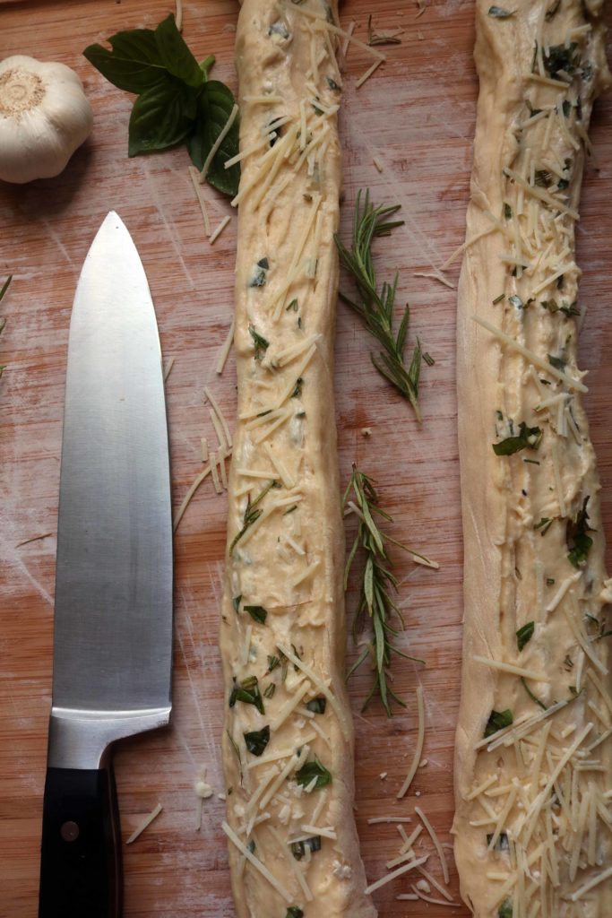 Slicing herb stuff cheese bread before braiding.