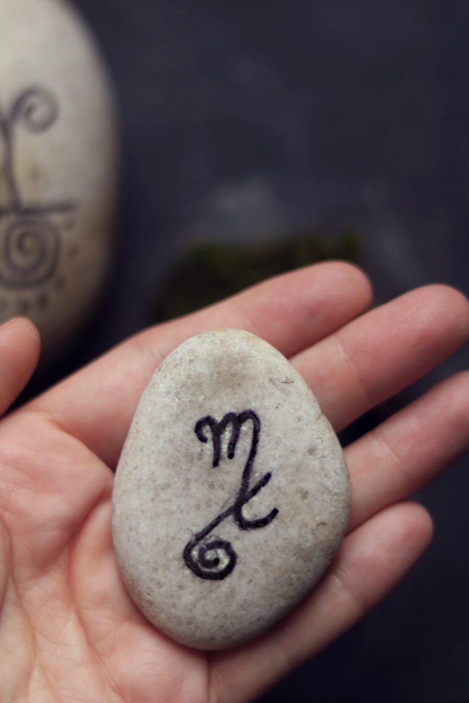 Sigil stone with astrological symbol for Scorpio and an inverted #9.